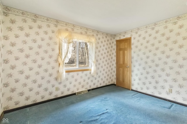 spare room featuring wallpapered walls, baseboards, and visible vents