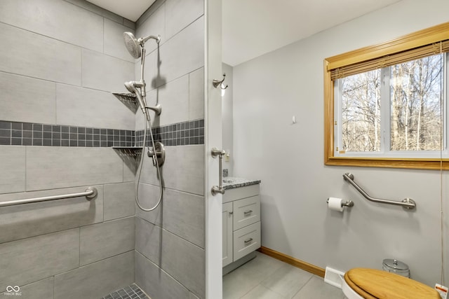 bathroom with vanity, visible vents, baseboards, a tile shower, and toilet