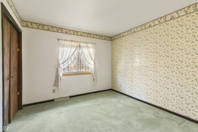 unfurnished bedroom featuring visible vents, baseboards, and carpet