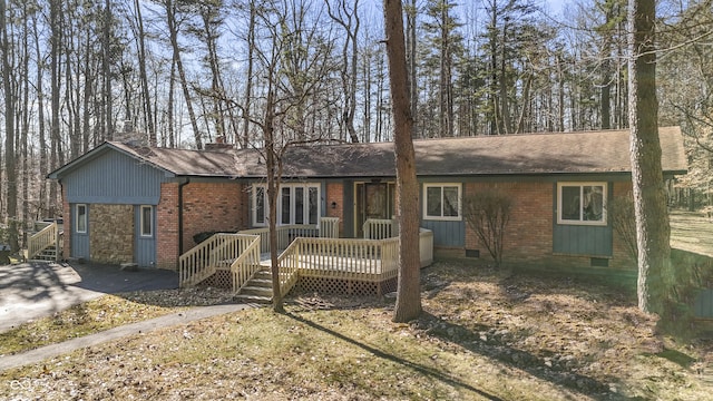 ranch-style house with crawl space, a deck, a chimney, and brick siding