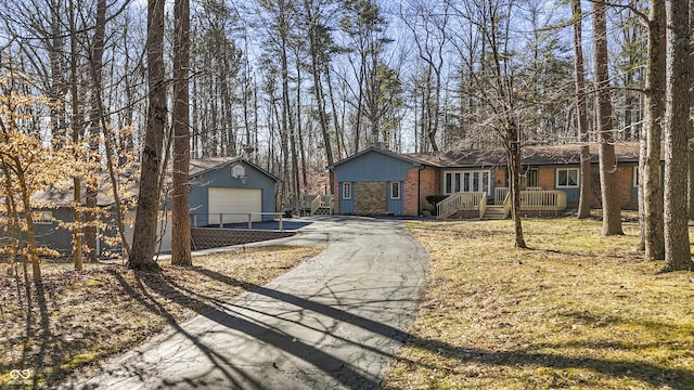 view of front of house featuring brick siding, a garage, and an outdoor structure