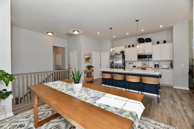 dining room with recessed lighting, visible vents, baseboards, and wood finished floors