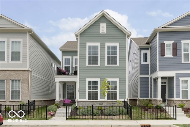 view of front facade with a fenced front yard and a balcony