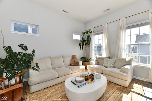 living area featuring visible vents and wood finished floors