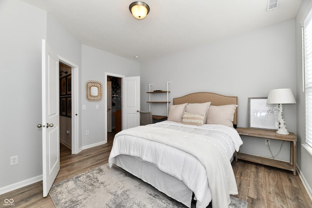 bedroom featuring visible vents, baseboards, and wood finished floors