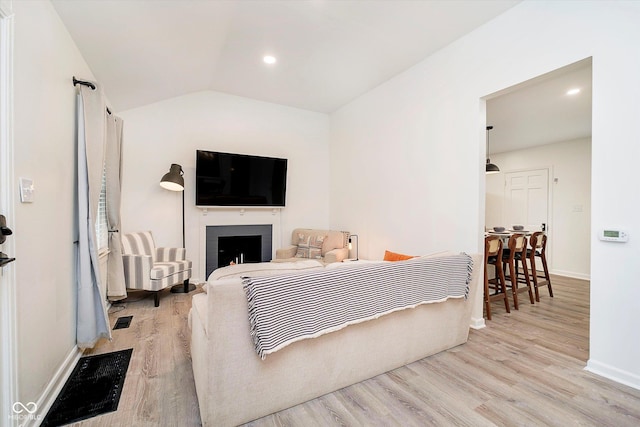 living area with a fireplace, vaulted ceiling, wood finished floors, and baseboards