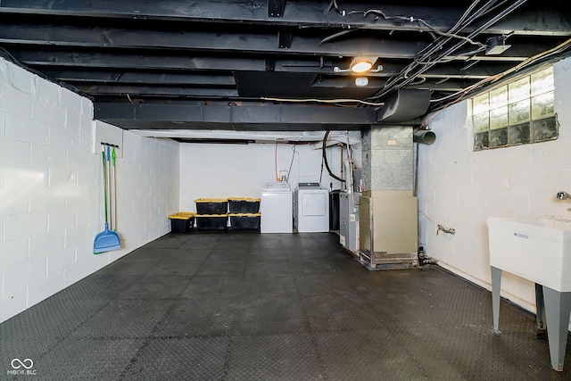 unfinished basement with a dark floor, heating unit, and separate washer and dryer