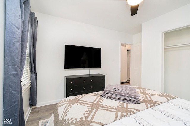 bedroom featuring a ceiling fan, baseboards, and wood finished floors