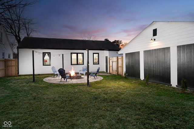 back of house with a lawn, an outdoor fire pit, a patio, and fence