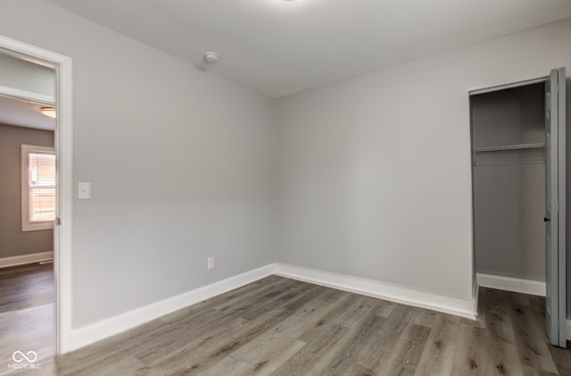 301 Villa Ave, Indianapolis, IN 46201 - unfurnished bedroom featuring a closet, baseboards, and wood finished floors