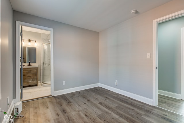 301 Villa Ave, Indianapolis, IN 46201 - unfurnished bedroom with wood finished floors, baseboards, ensuite bathroom, and a sink