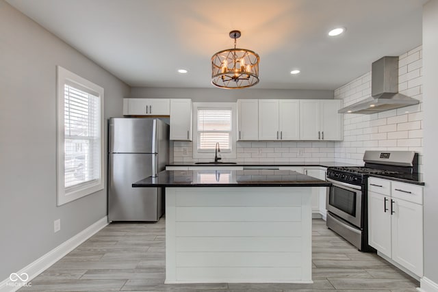 301 Villa Ave, Indianapolis, IN 46201 - kitchen with a center island, wall chimney range hood, a chandelier, stainless steel appliances, and a sink