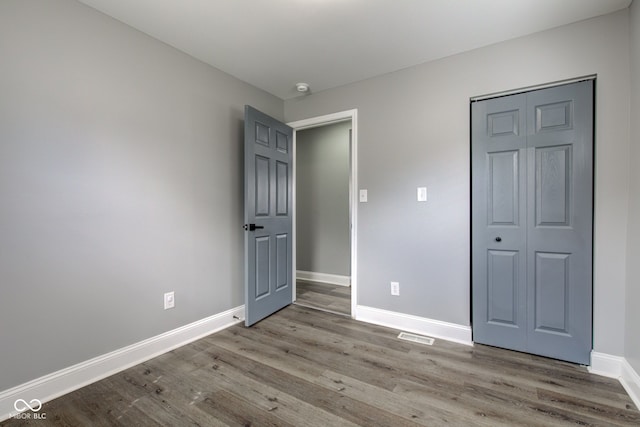301 Villa Ave, Indianapolis, IN 46201 - unfurnished bedroom featuring a closet, baseboards, and wood finished floors