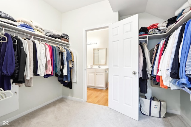 walk in closet featuring vaulted ceiling and light carpet