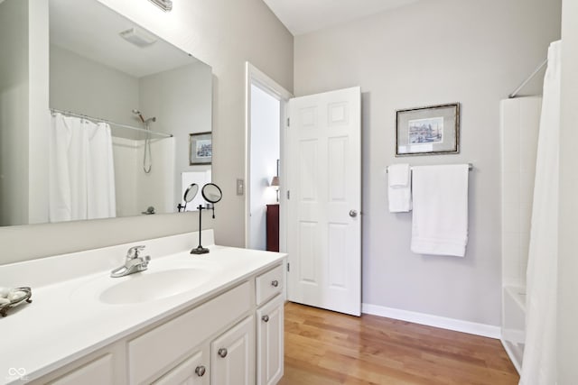 bathroom featuring vanity, baseboards, and wood finished floors