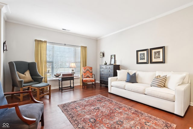 living area with crown molding, wood finished floors, baseboards, and visible vents