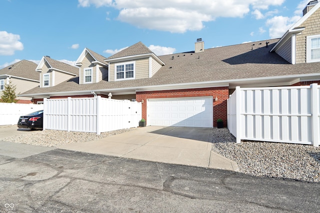 view of front of house featuring brick siding, an attached garage, concrete driveway, and fence