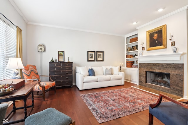 living room with dark wood finished floors, crown molding, built in features, and a premium fireplace