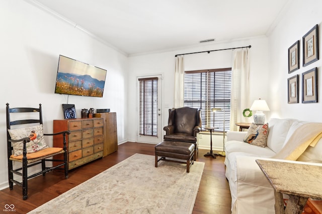 living room featuring visible vents, baseboards, crown molding, and dark wood-type flooring