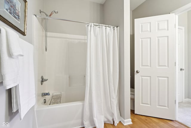 bathroom with wood finished floors and shower / bath combination with curtain