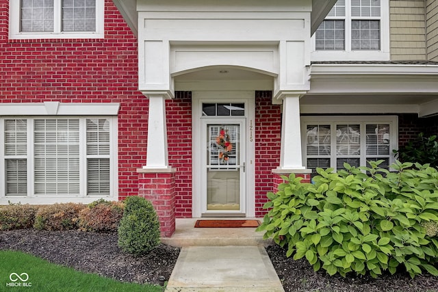 view of exterior entry featuring brick siding