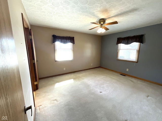 spare room with visible vents, baseboards, a healthy amount of sunlight, and ceiling fan