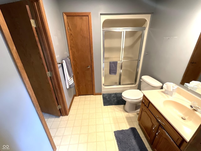 full bath with an enclosed shower, toilet, and vanity