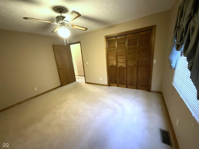 unfurnished bedroom featuring a closet, visible vents, light carpet, and baseboards