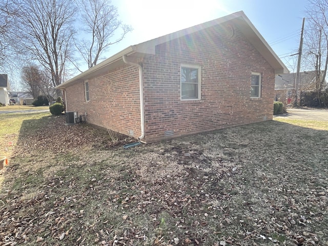 view of side of property featuring crawl space, brick siding, and cooling unit