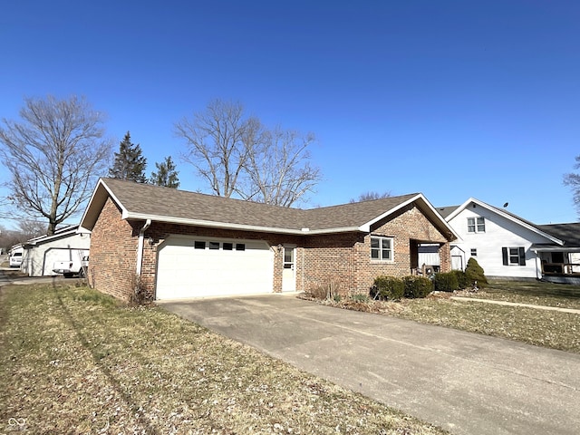 single story home with concrete driveway, a garage, brick siding, and roof with shingles