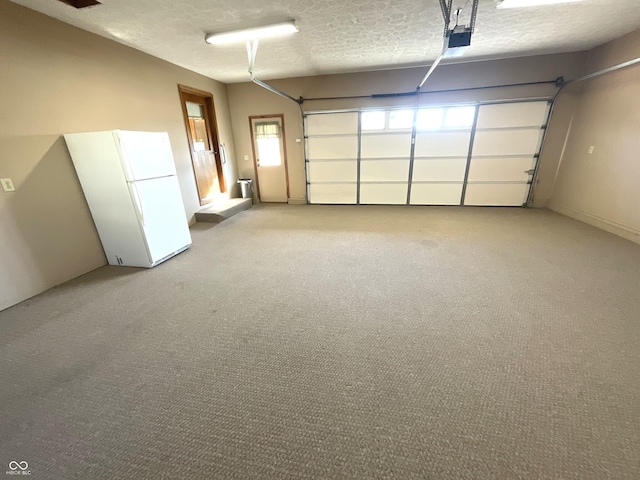 garage with a garage door opener and freestanding refrigerator