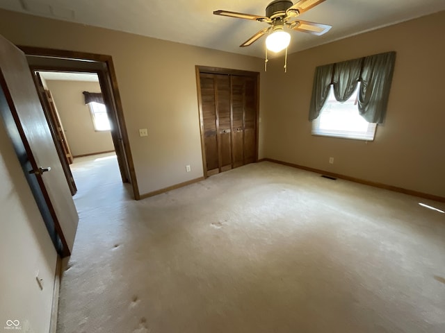 unfurnished bedroom with visible vents, multiple windows, baseboards, and a closet