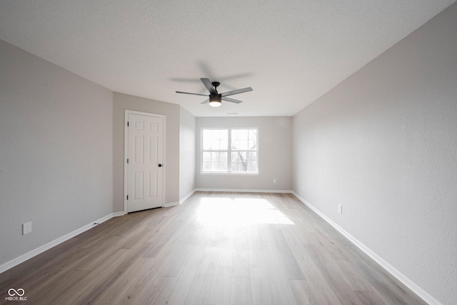 empty room featuring ceiling fan, a textured ceiling, baseboards, and wood finished floors