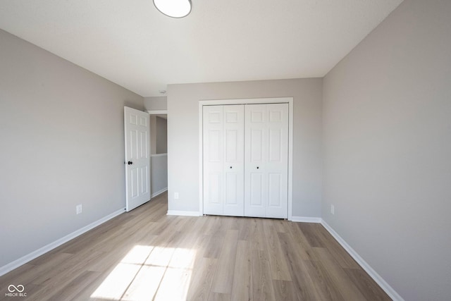 unfurnished bedroom with a closet, baseboards, and wood finished floors