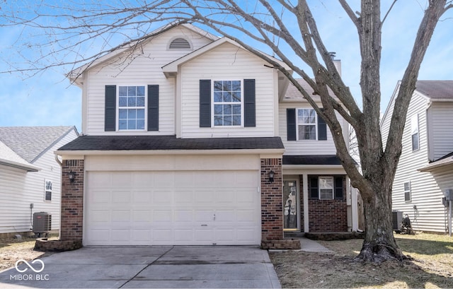 traditional-style house featuring brick siding, central AC, concrete driveway, and an attached garage