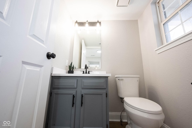 bathroom with vanity, toilet, and baseboards