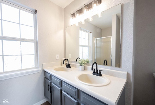 bathroom featuring a healthy amount of sunlight, a stall shower, and a sink