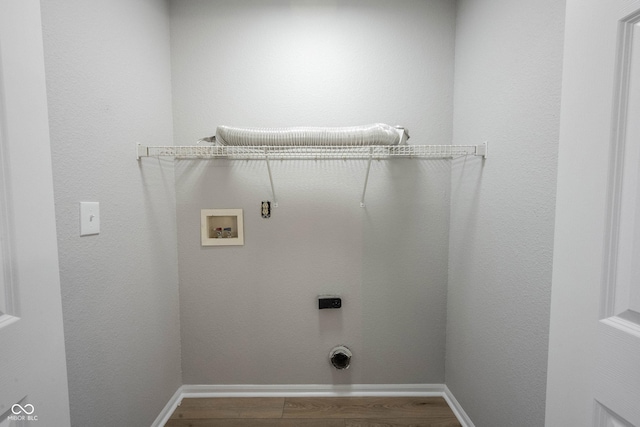 clothes washing area featuring hookup for a washing machine, wood finished floors, baseboards, laundry area, and electric dryer hookup