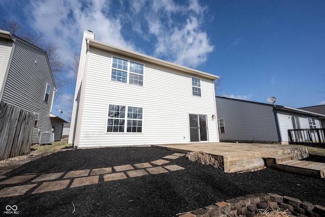 back of house featuring a chimney, central AC, and a deck