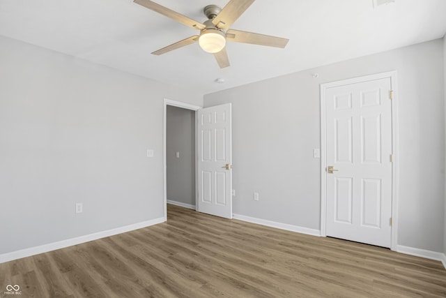 unfurnished bedroom featuring a ceiling fan, wood finished floors, and baseboards