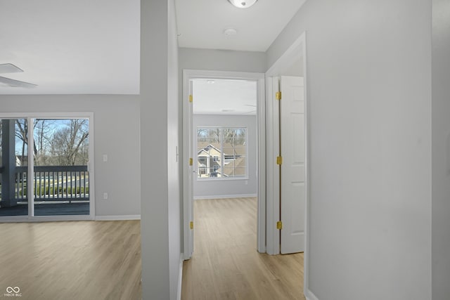 hallway featuring light wood-style floors and baseboards