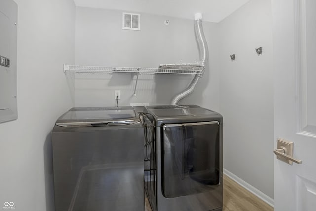 laundry room featuring visible vents, baseboards, laundry area, wood finished floors, and independent washer and dryer