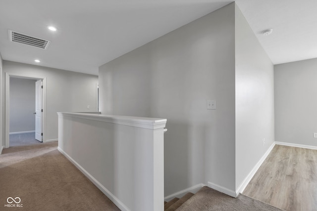 hall featuring recessed lighting, an upstairs landing, visible vents, and baseboards