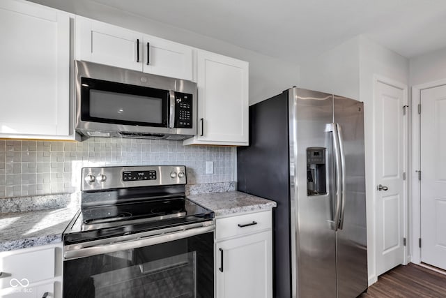 kitchen featuring white cabinetry, backsplash, dark wood-style flooring, and appliances with stainless steel finishes