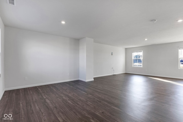 empty room with visible vents, recessed lighting, baseboards, and dark wood-style flooring