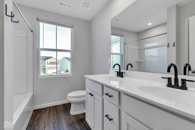 bathroom featuring wood finished floors, visible vents, and a sink