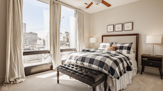 bedroom featuring light carpet, visible vents, and a ceiling fan