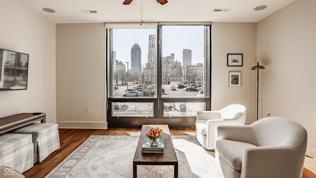 living room featuring a view of city, wood finished floors, visible vents, and expansive windows