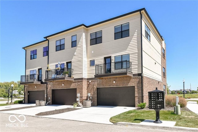 townhome / multi-family property featuring concrete driveway, a garage, and brick siding