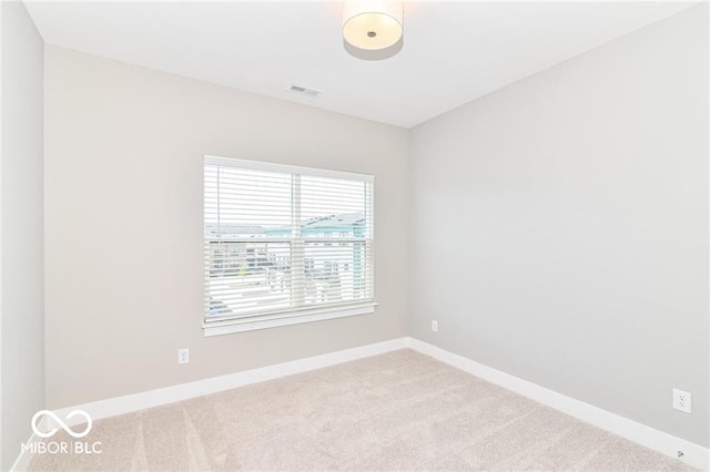 carpeted empty room featuring visible vents and baseboards